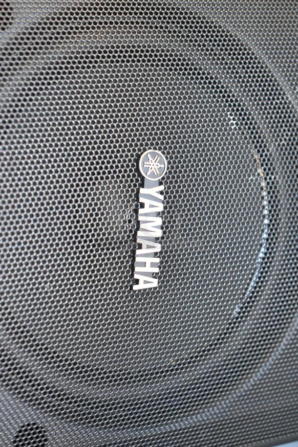 Yamaha NS-AW150 speaker close-up, black mesh grill with Yamaha logo. 8 ohm, outdoor model. Auction includes 4 speakers.