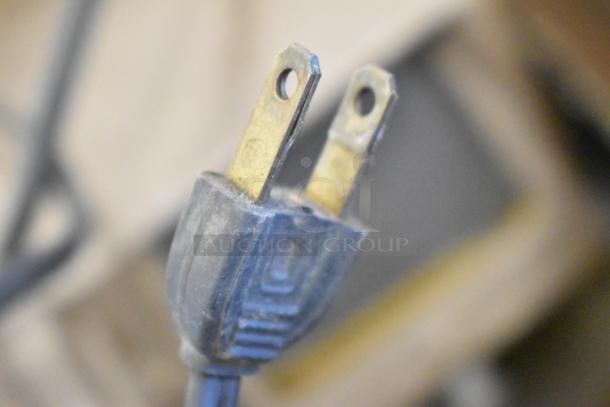 Close-up of a two-prong electrical plug from a lot including a Mansfield 950 8mm Editor, showing moderate wear.