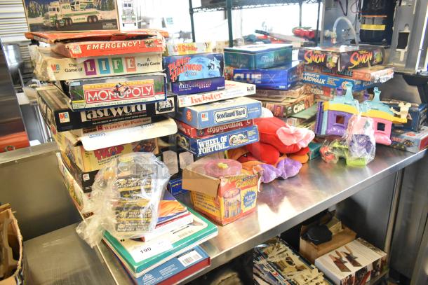 Tier lot of board games and books on a table, featuring Monopoly, Life, Twister, Simon. Various conditions and packaging.
