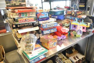 Tier lot of board games and books on a table, featuring Monopoly, Life, Twister, Simon. Various conditions and packaging.