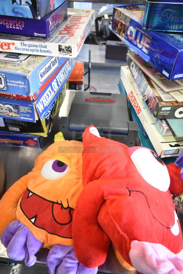 Tier lot of various items including board games like Clue, Monopoly, Twister, and plush toys. Good condition.