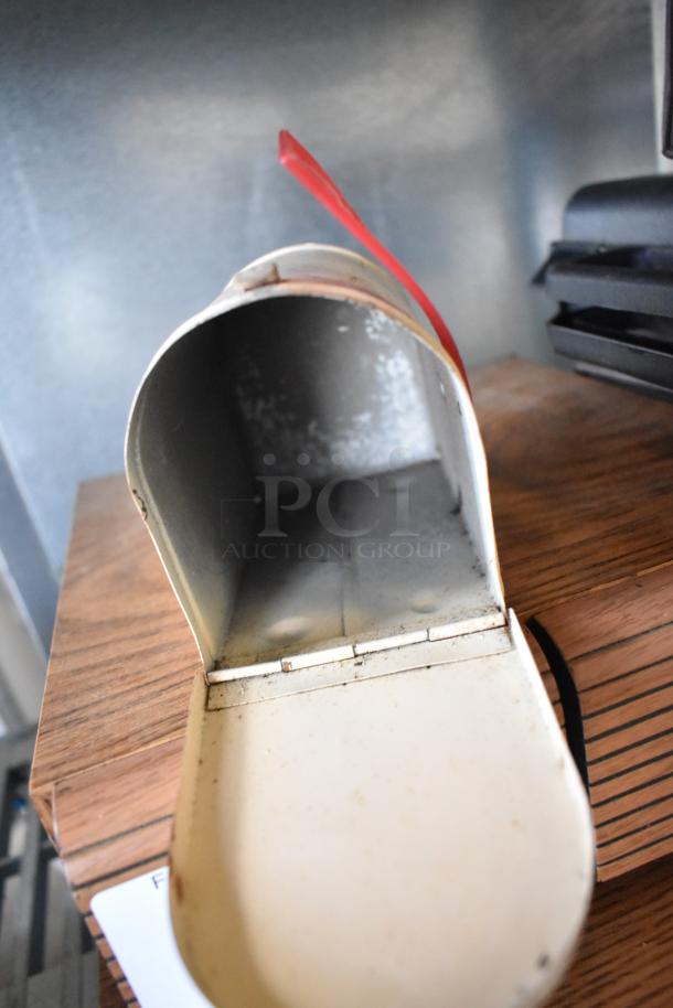 Open vintage metal mailbox with red flag, showing interior condition; part of an auction lot including Marsand bag and cassette tapes.