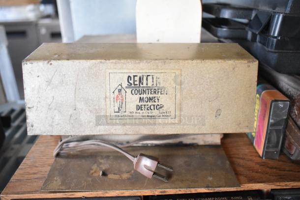 Vintage Sentinel Counterfeit Money Detector with power cord. Visible wear. Includes cassette tapes, Marsand bag, and mailbox.