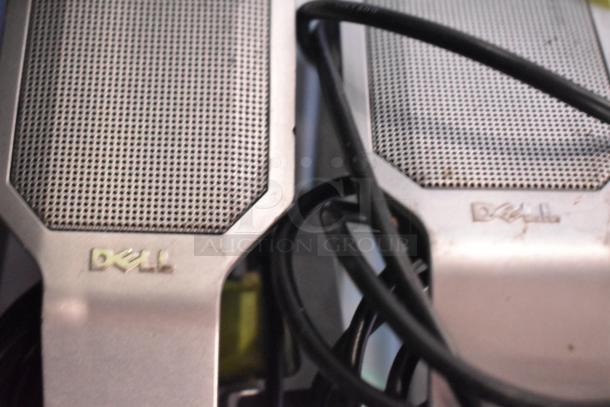 Dell speakers with metal grille, visible cables, and logo. Part of auction lot with multimedia computer and Sony sound system.