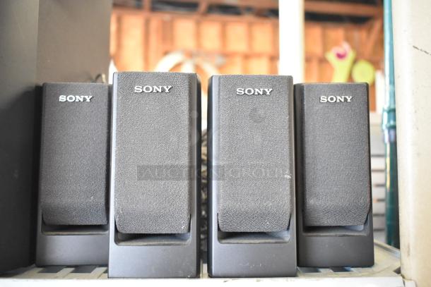 Four Sony speakers in black, displaying the Sony logo. They appear in good condition, with minor signs of wear.