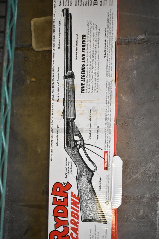 Red Ryder BB Gun in original box with illustration and product details visible. Box shows model specifications and features.