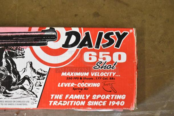 Daisy Red Ryder BB Gun box, red with target design, 650 Shot, 350 FPS, .177 cal, lever-cocking. Classic sporting item.