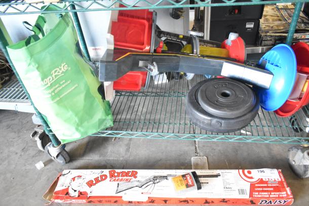 Two tier shelf with fishing lures, windchimes, Nintendo Switch controller holder, green ShopRite bag, weights, and a Red Ryder Carbine box.