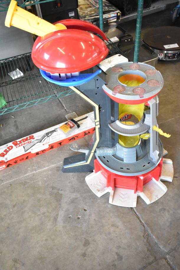 Two-tier lot with various items including fishing lures, windchimes, and a Nintendo Switch controller holder. Red and blue plastic structure, used condition.