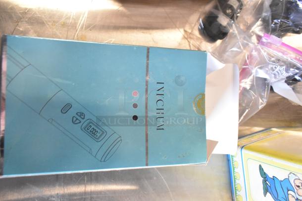 Two-tier lot with a box labeled "INKCHUM," fishing lures, windchimes, and a Nintendo Switch controller holder. Various items.