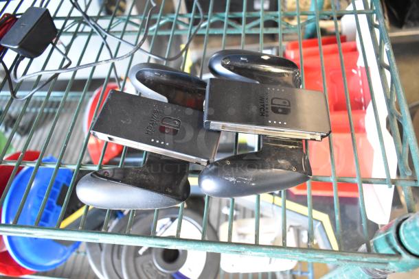 Two Nintendo Switch controller holders on a metal shelf, part of a mixed lot with fishing lures and windchimes.