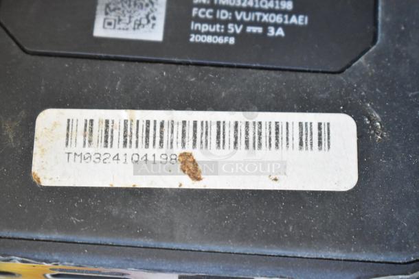 Barcoded label with serial number TM0324104198 on a black surface, including item specifications and scuffs.