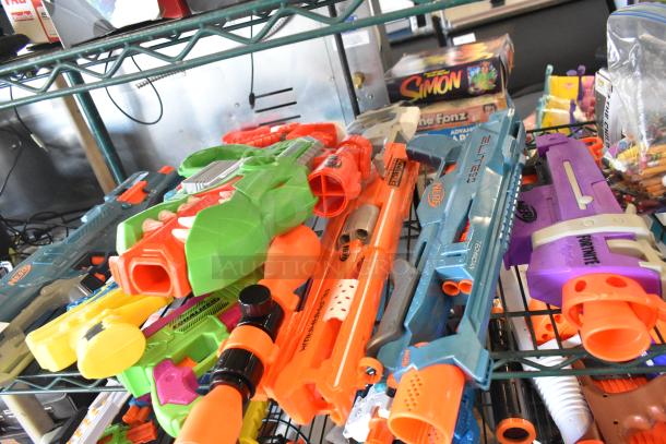Two-tier shelf with various toy guns, including colorful Nerf models. Additional items like board games visible. Good condition.