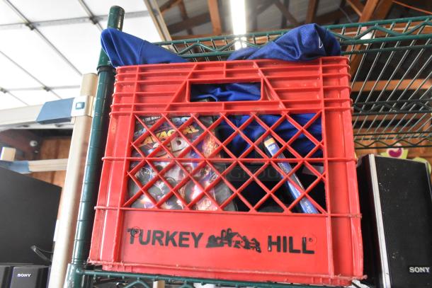 Two-tier crate with mixed items including Sony speaker, DVDs, fabric, marked "Turkey Hill," auction lot.