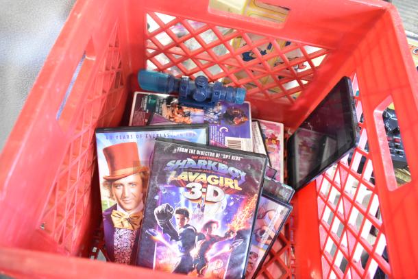 Red crate with assorted items, including DVD cases for "Charlie and the Chocolate Factory" and "Sharkboy and Lavagirl 3D."