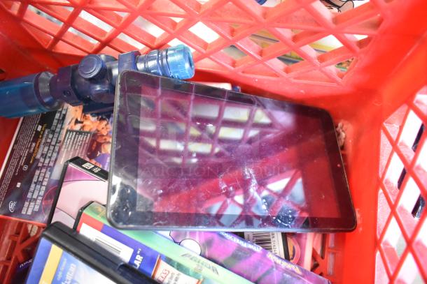 Two-tier lot in red crate featuring a Sony speaker, tablet, various DVDs, and toys including a Star Wars Darth Vader doll.