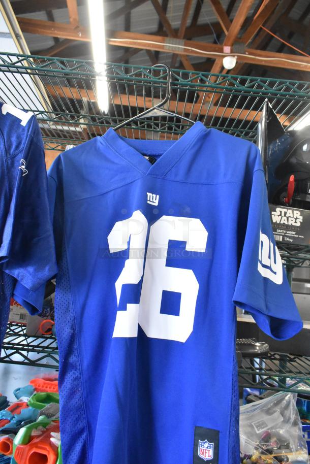 Blue NFL jersey with number 26, alongside Star Wars Darth Vader doll. Includes Sony speaker and Jacob doll. Multi-item lot.