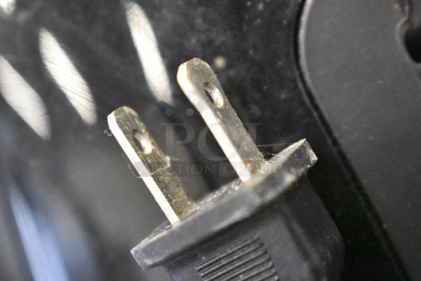 Close-up of a power plug for the Philips HD9230 Air Fryer, showing standard U.S. prongs, slightly worn, against a black background.