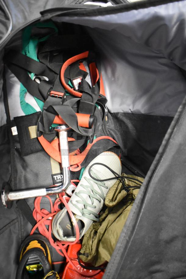 BagBoy bag with jump rope, TRX tactical gear, shoes, and assorted contents. Visible wear, ideal for active use.