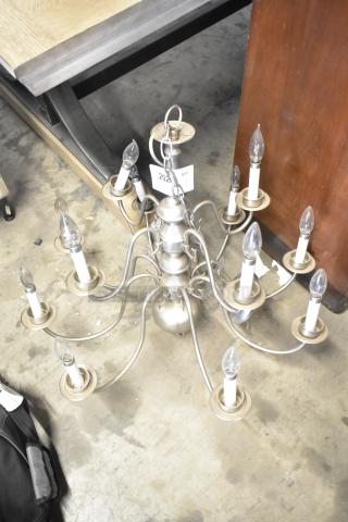 Silver metal chandelier with ten candle-style lights, elegant curved arms, and chain for hanging. Item tag "202".