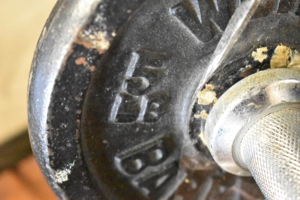Close-up of a 15 lb dumbbell weight plate with visible wear and a knurled handle.