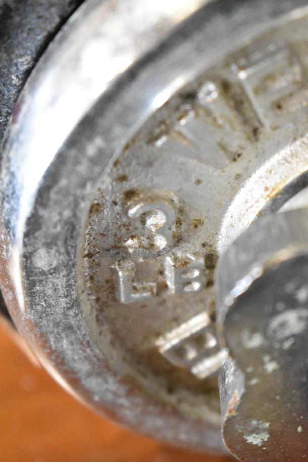 Close-up image of a metal dumbbell end marked "3 LB," showing wear. Auction item: 2 Dumbbells, double bid offer.