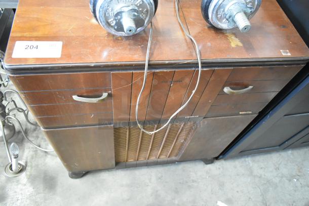 Victrola wood-pattern counter with record player, vintage look, multiple drawers, visible wear, item number 204 tag.