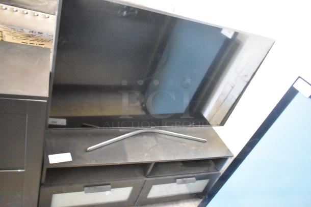 Samsung television with stand, sleek design, black finish. Local pickup only. Buyer receives 2 items per bid.