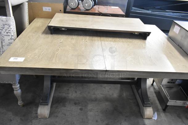 Wooden dining table with extension leaf, light finish, in good condition. Includes six matching chairs. Auction item tag visible.