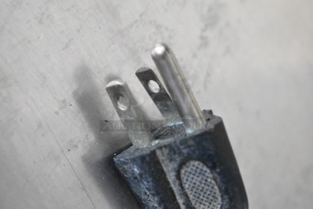 Close-up of a metal plug on a Win-holt WHSS-1 countertop film wrapper machine, 120 volts, 1 phase.