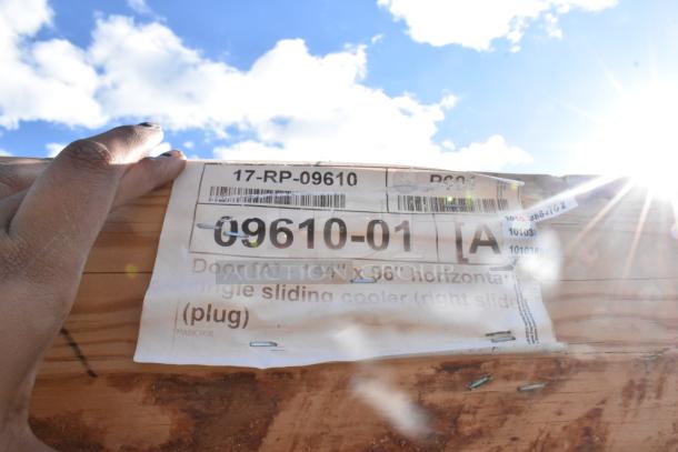 Brand new "scratch and dent" 144"x96" sliding door. Label reads: 09610-01, Door [A], with visible product codes.