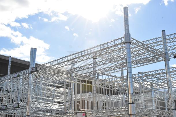 Chrome finish 6-tier wire shelving unit with contents, requires dismantling by buyer, shown outdoors under sunlight.