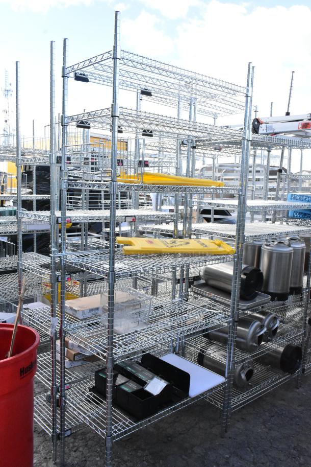 Chrome finish 6 tier wire shelving unit with contents, including wet floor caution signs. Buyer must dismantle.