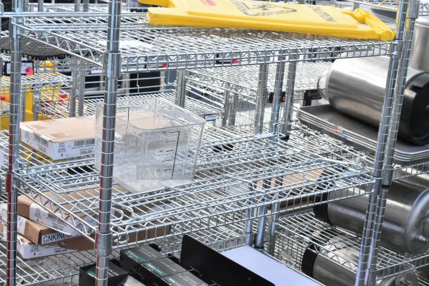 Chrome finish 6-tier wire shelving unit with contents, including yellow wet floor caution signs. Dismantling required.
