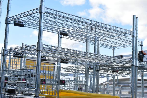 Chrome finish 6-tier wire shelving unit with wet floor caution signs. Buyer must dismantle. Consider freight charges.