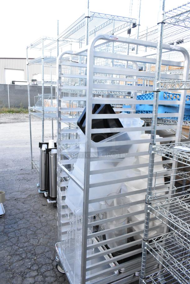 Metal commercial pan transport rack with contents, on commercial casters. Used condition, sturdy metal design, ideal for kitchen use.