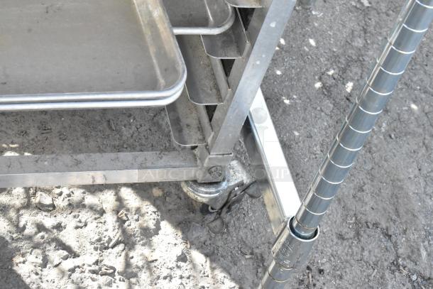 Metal cart with baking pans, features sturdy wheels and stackable design. Metal construction, suitable for industrial use.