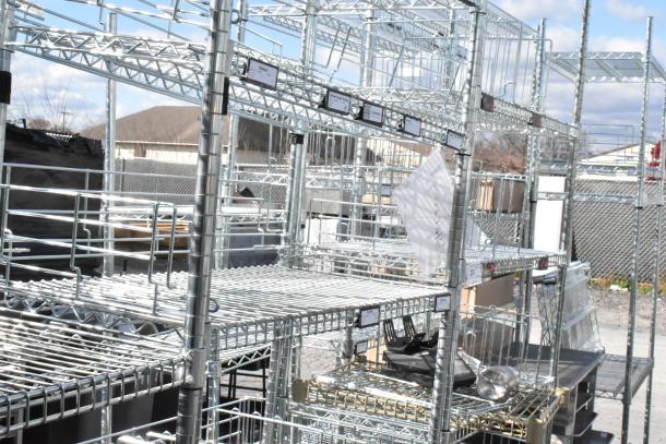 Chrome finish 5-tier wire shelving unit, outdoor setting, requires buyer dismantling for shipping, consider freight charges.