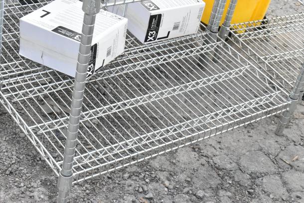 Chrome finish 4-tier wire shelving unit. Includes visible boxes. Buyer must dismantle. Consider freight charges.