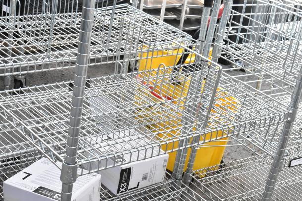 Chrome finish 4-tier wire shelving unit featuring adjustable shelves. Good condition; buyer must dismantle for shipping.