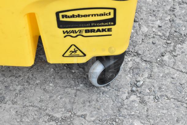 Yellow Rubbermaid WaveBrake mop bucket with wringing attachment, commercial casters, and slip caution symbol.