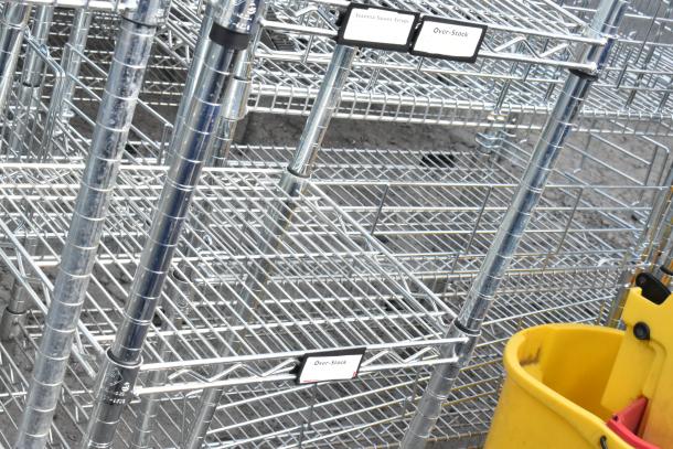 Chrome finish 6-tier wire shelving unit with visible labels for seasonal sauces and over-stock. Buyer must dismantle.