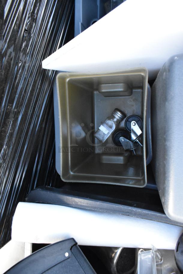 Poly trash can with miscellaneous contents including a keg part, small bottle, and casters. Auction lot includes four such units.