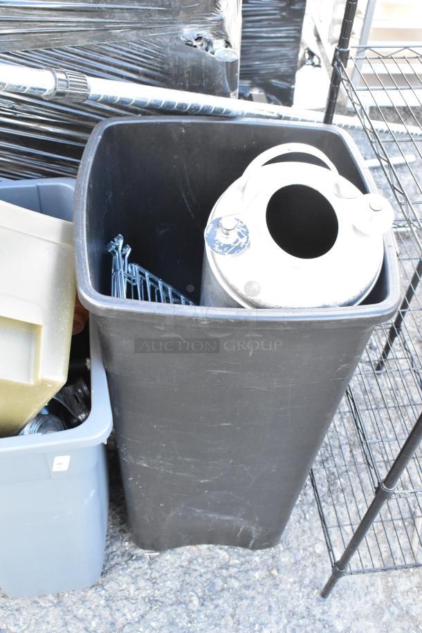 Four poly trash cans with assorted contents, including a keg, shown in used condition.