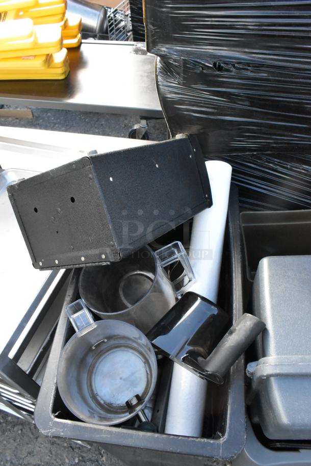 Four poly trash cans containing various items, including a keg, metal mugs, and plastic racks, wrapped in black and yellow plastic.