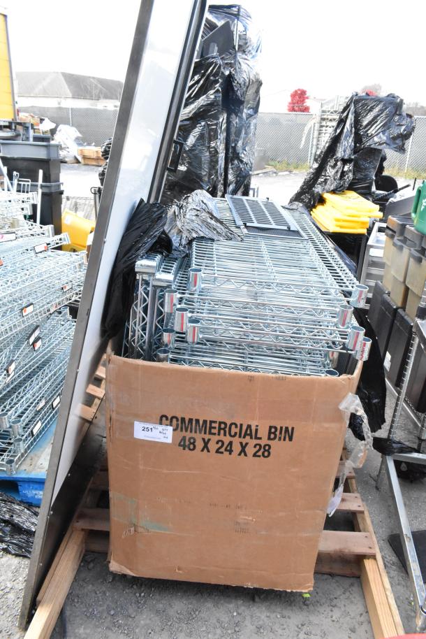 Lot of wire shelves in a commercial bin, dimensions 48x24x28, on wooden pallet, in used condition outdoors.