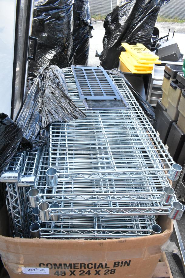 Lot of wire shelves in good condition, stacked in a commercial bin, dimensions 48x24x28 inches, suitable for storage use.