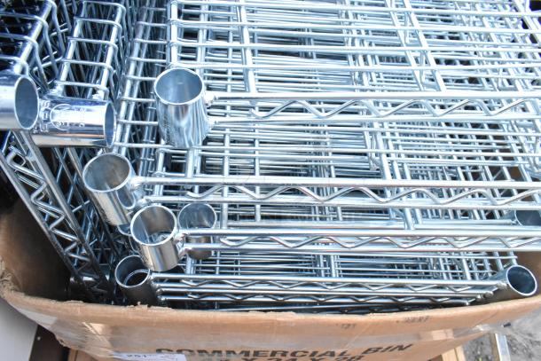 Lot of wire shelves, chrome-plated, in new condition. Includes multiple shelves, visible connectors, stored in a cardboard box.