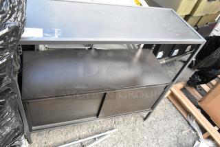 Black metal and wood television stand, dual shelves, sliding doors, slight surface wear, auction tag on top.