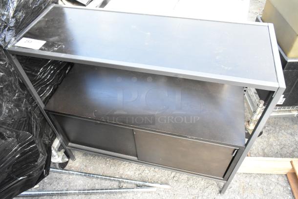 Black metal television stand with double shelves and sliding doors, in fair condition, minor surface scratches, item tag "253".